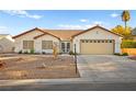 Inviting single-story home with desert landscaping, red tile roof, and a two-car garage at 5009 Elm Grove Dr, Las Vegas, NV 89130