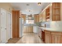Well-lit kitchen featuring light wood cabinets, tiled backsplash, tile floors, and modern white appliances at 602 Paloma Dr, Boulder City, NV 89005