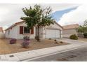 Inviting single-story home showcasing a red tile roof, neutral stucco, and a two-car garage at 629 Bright Lights Ave, North Las Vegas, NV 89031