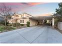 View of attached carport and three-car garage with a long driveway at 7600 Pleasant Colony Ct, Las Vegas, NV 89131