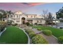 Charming two-story home featuring an arched entrance, manicured lawn, and attached carport at 7600 Pleasant Colony Ct, Las Vegas, NV 89131