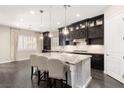 Elegant kitchen featuring dark cabinetry, stainless steel appliances, and a large center island with seating at 7763 Brisk Ocean Ave, Las Vegas, NV 89178