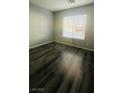 A cozy bedroom with neutral walls, a window, and durable floors at 7985 Flower Seeds St, Las Vegas, NV 89139