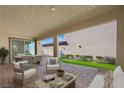 Charming covered patio featuring brick flooring, modern seating, and a seamless transition to an outdoor area at 1091 E Sunset Rd, Henderson, NV 89011