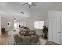 Staged living room featuring vaulted ceilings, fan, and sliding doors to the backyard at 1163 Tumbling River Ave, Henderson, NV 89052