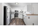 Kitchen featuring stainless steel appliances, white cabinets, and wood-look floors at 1830 N Buffalo Dr # 1019, Las Vegas, NV 89128