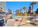 Outdoor swimming pool with lounge chairs, palm trees, and high-rise building in the background at 2000 N Fashion Show Dr # 5326, Las Vegas, NV 89109