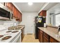 Functional kitchen featuring tile floors and countertops, ample cabinet space, and essential appliances at 2606 S Durango Dr # 276, Las Vegas, NV 89117