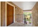 Inviting entryway featuring a solid wood door, textured walls, and a glimpse of lush greenery at 5060 Indian River Dr # 382, Las Vegas, NV 89103