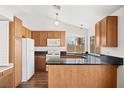 Traditional kitchen featuring wood cabinets, dark countertops, and modern appliances at 6130 Desert Sun Dr, Las Vegas, NV 89110