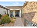 Inviting home entrance features a stone accent wall, a tiled walkway, and desert landscaping at 7165 N Grand Canyon Dr, Las Vegas, NV 89149