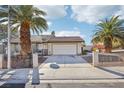 Charming home featuring a spacious driveway framed by mature palm trees at 8805 Pavia Dr, Las Vegas, NV 89117