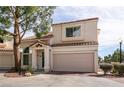 Charming townhome with a tile roof, blue door, and two-car garage in a well-maintained community at 8872 Hampton Green Ave, Las Vegas, NV 89129