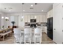 Well-lit kitchen featuring an island with bar seating, granite countertops, modern appliances, and a dining area at 10052 Silver Comet Ct, Las Vegas, NV 89178