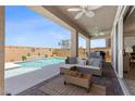 Inviting outdoor living space featuring a covered patio, a refreshing pool with waterfall feature, and comfortable seating at 10052 Silver Comet Ct, Las Vegas, NV 89178