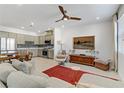 Open concept living room and kitchen features a modern fan, a large picture window, and neutral decor at 1103 Tektite Ave, Henderson, NV 89011