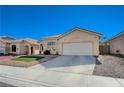 Inviting single-story home with manicured lawn and desert landscaping, complemented by a two-car garage at 1421 Hometown Ave, Henderson, NV 89074