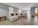 Spacious living room featuring a large sectional sofa, stylish decor, and wood-look tile flooring at 1421 Hometown Ave, Henderson, NV 89074