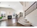 Bright living room features a fireplace, plantation shutters, dark wood flooring, and a staircase at 1426 Clipperton Ave, Henderson, NV 89074