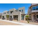 Contemporary townhome showcases stucco facade, small trees, balcony, and a vibrant blue front door at 1479 Melodic Lark Dr, Las Vegas, NV 89138