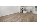 Bright living area with wood-look flooring, leading to a kitchen and staircase at 1479 Melodic Lark Dr, Las Vegas, NV 89138