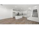 Open-concept space with wood-look tile, white walls, and a kitchen with modern cabinetry at 1479 Melodic Lark Dr, Las Vegas, NV 89138