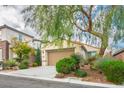 Single Gathering home showcasing a lush front yard, mature trees and a two-car garage at 2629 Chateau Clermont St, Henderson, NV 89044