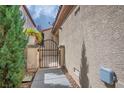 Exterior side yard view with a secure black metal gate and lush landscaping at 2629 Chateau Clermont St, Henderson, NV 89044