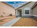 Inviting home exterior showcasing desert landscaping, covered entry, and textured stone accents at 3334 Flying Colt Ct, North Las Vegas, NV 89032