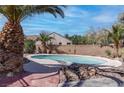 Backyard oasis with private pool surrounded by desert landscaping and a mature palm tree at 3640 Chateau Meadow St, Las Vegas, NV 89129