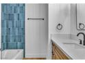 This half bathroom has a blue tiled wall, a modern sink, and brushed metal hardware at 528 Sheffield Dr, Henderson, NV 89014