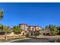 Upscale stucco home featuring a turret, tile roof, and manicured landscaping in a luxury neighborhood at 6 Fire Rock Ct, Las Vegas, NV 89141