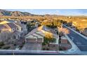 An aerial view captures the property with desert landscape and neighborhood, showcasing mountain views at 6944 Puetollano Dr, North Las Vegas, NV 89084