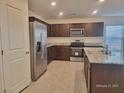 The kitchen features stainless steel appliances, granite countertops and tile flooring at 7246 Copper Grove Ave, Las Vegas, NV 89113