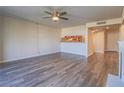 Bright living area features open layout to kitchen, ceiling fan, and modern flooring at 725 N Royal Crest Cir # 213, Las Vegas, NV 89169