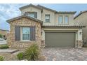 Two-story home showcasing a stone exterior, brown shutters, a two car garage and landscaped yard at 8125 Skye Vineyard Dr, Las Vegas, NV 89166