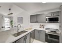 Modern kitchen showcasing white countertops, stainless steel appliances, gray cabinets, with eat in kitchen and lots of sunlight at 1800 Edmond St # 215, Las Vegas, NV 89146