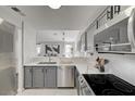 Bright kitchen with stainless steel appliances, gray cabinets, white countertops, and herringbone backsplash at 1800 Edmond St # 215, Las Vegas, NV 89146