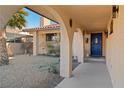 Exterior entryway with archways leading to a blue front door and desert landscaping at 2111 River City Dr, Laughlin, NV 89029