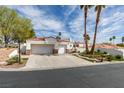 Attractive single-story house featuring a two-car garage, palm trees and well-manicured lawn at 230 Pintale Cir, Henderson, NV 89074