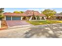 Charming single-story home featuring a terracotta roof, three-car garage, and a well-manicured front lawn at 2501 Wimbledon Dr, Las Vegas, NV 89107