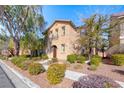 Two story home with stucco exterior and mature landscaping in the front yard on a sunny day at 3204 Romanesque Art Ave, Henderson, NV 89044