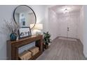 Bright entryway with wood floors, console table, decorative mirror, and white double doors at 3503 Luca Point Ave, Henderson, NV 89044