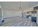 Open-concept living space with gray wood floors, recessed lighting, and a view into the kitchen at 376 E Erin St # 1, Pahrump, NV 89048