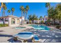 Community pool and hot tub area with lounge seating offers a relaxing oasis in a tropical setting with palm trees at 4555 E Sahara Ave # 132, Las Vegas, NV 89104