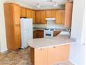 Bright kitchen with wood cabinets, white appliances, and breakfast bar at 4905 Morning Falls Ave, Las Vegas, NV 89131