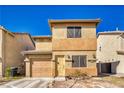 Charming tan stucco two-story home with a garage, front yard landscaping and a covered entryway, enhancing its curb appeal at 5179 Floralita St, Las Vegas, NV 89122