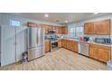 Traditional kitchen with wood cabinets, stainless steel appliances, and a light wood floor providing a functional cooking space at 5179 Floralita St, Las Vegas, NV 89122