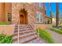 Charming entrance featuring a stone facade and a decorative wooden front door at 65 Luce Del Sole # 1, Henderson, NV 89011