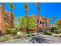 Southwest townhome displays mature landscaping with desert trees, plants, and a barrel-tile roof at 65 Luce Del Sole # 1, Henderson, NV 89011